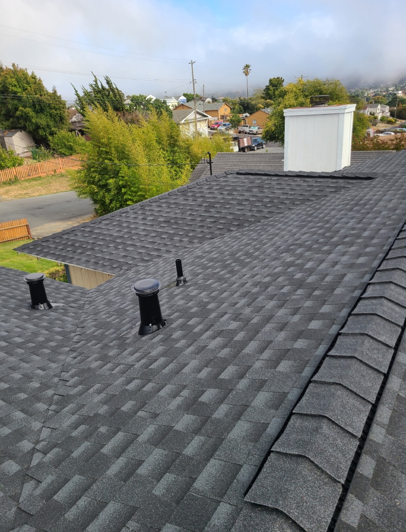 Old, weathered roof with curled and missing asphalt shingles before replacement